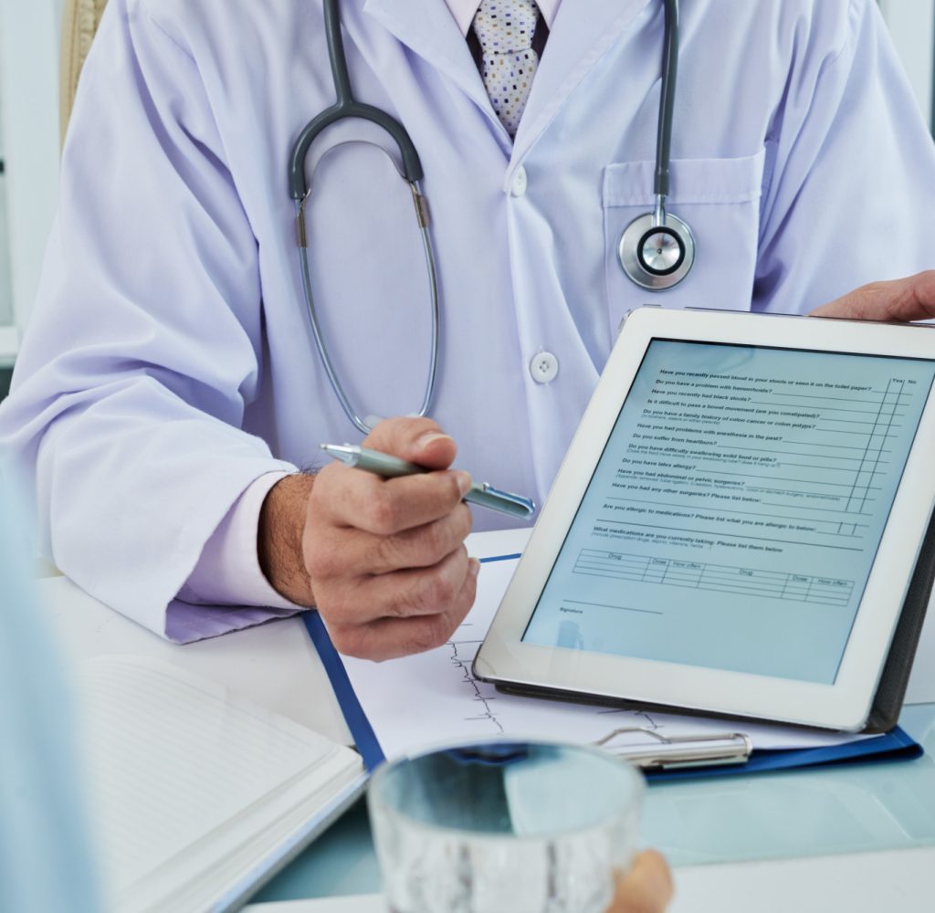unrecognizable-doctor-extending-digital-tab-anonymous-patient-fill-questionnaire